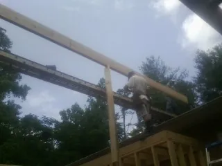 Carpenter setting a ridge beam over a new addition frame — Ice Dam Removal by Roofing Brothers in Moapa