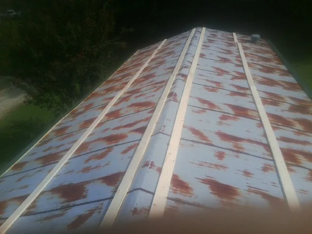 Rusted metal roof panels with new wood purlins before replacement — Storm Damage Roof Repair in Moapa by Roofing Brothers