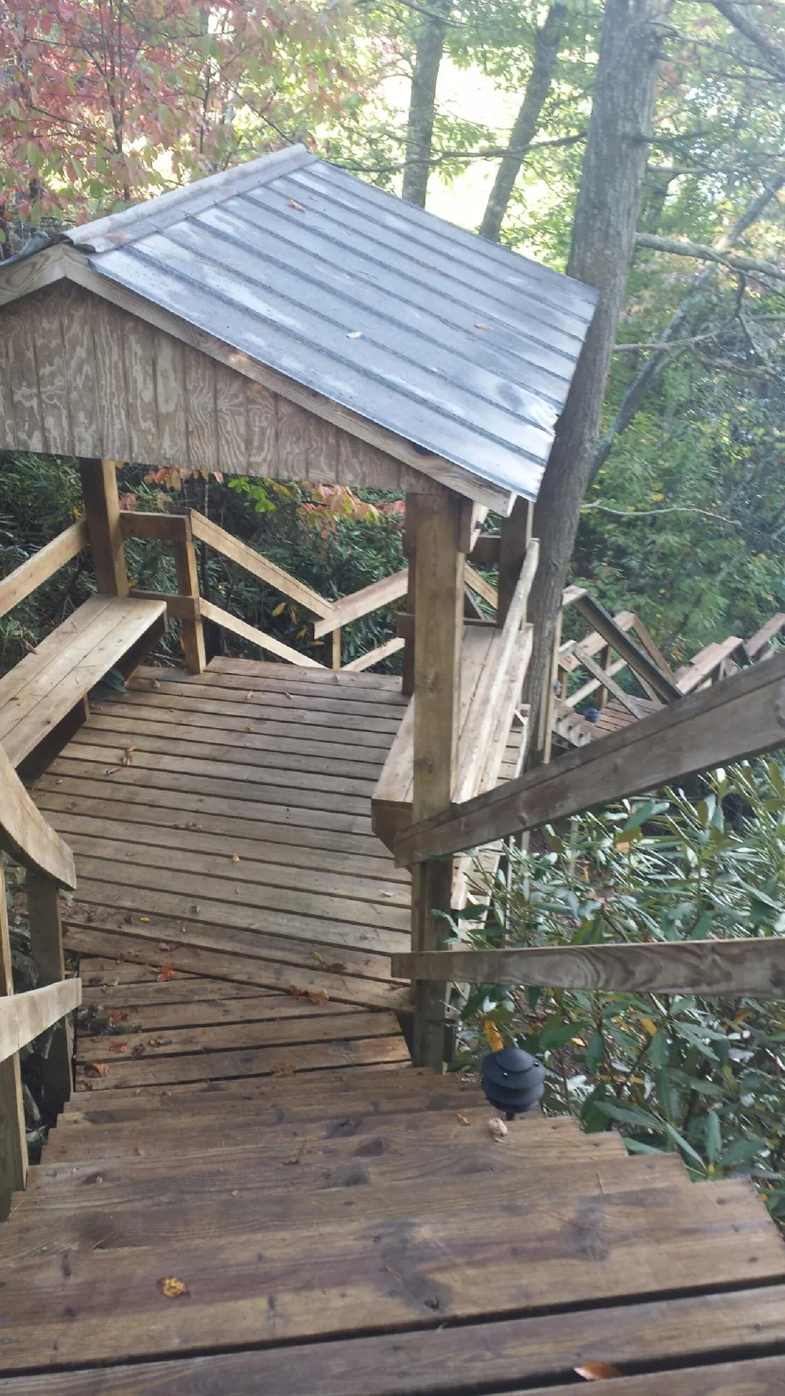 Metal roofed shelter over wooden steps on a wooded walkway — Skylight Repair & Installation work by our crew in Moapa
